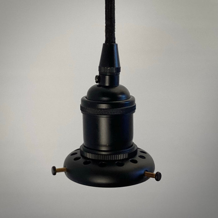 A side profile of a black industrial-style pendant light socket assembly hanging from a black cloth cord, showing the ventilated shade holder and adjustment screws.